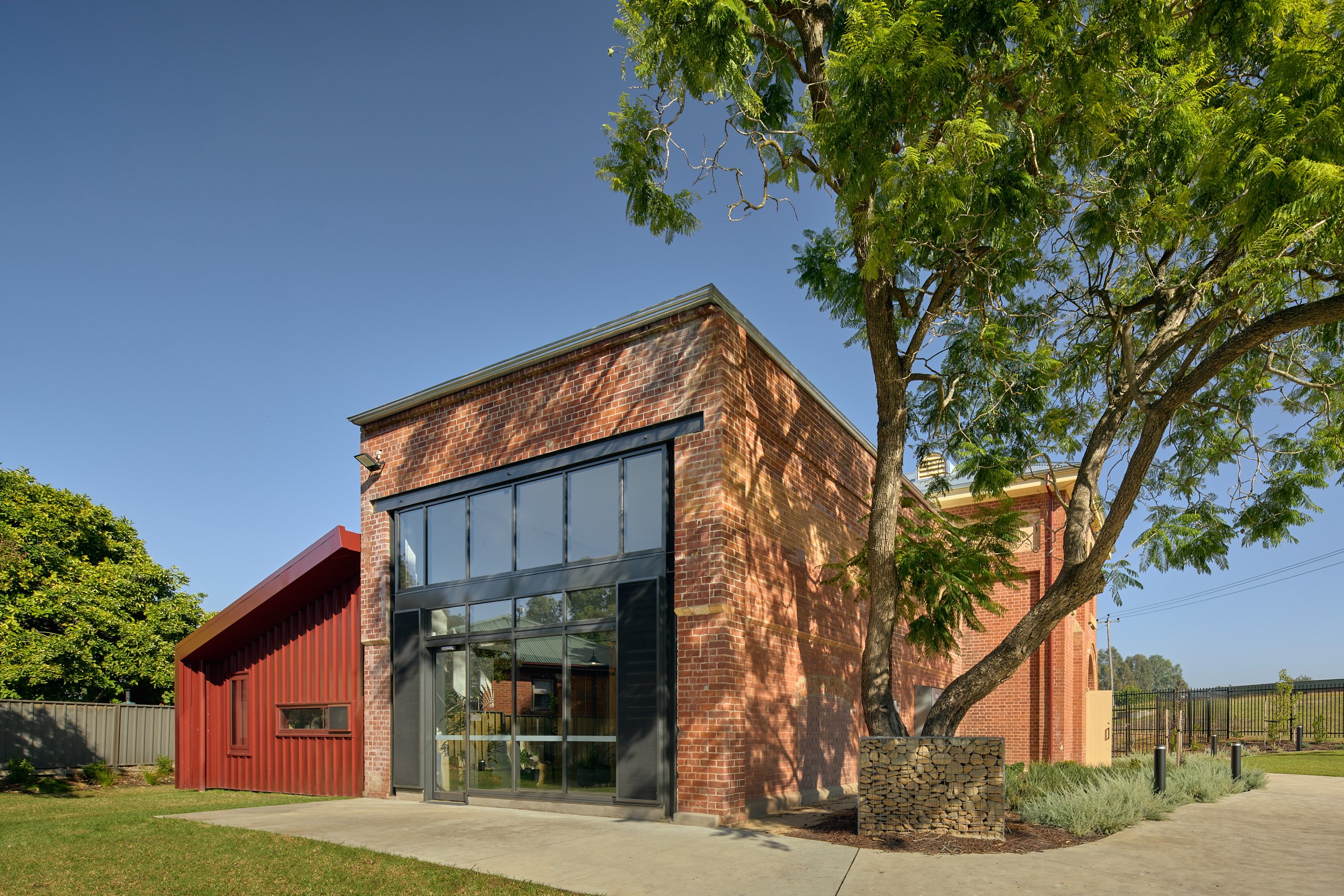 Brick arts building with large glass windows and surrounding trees in the Murray and North East Victoria region.