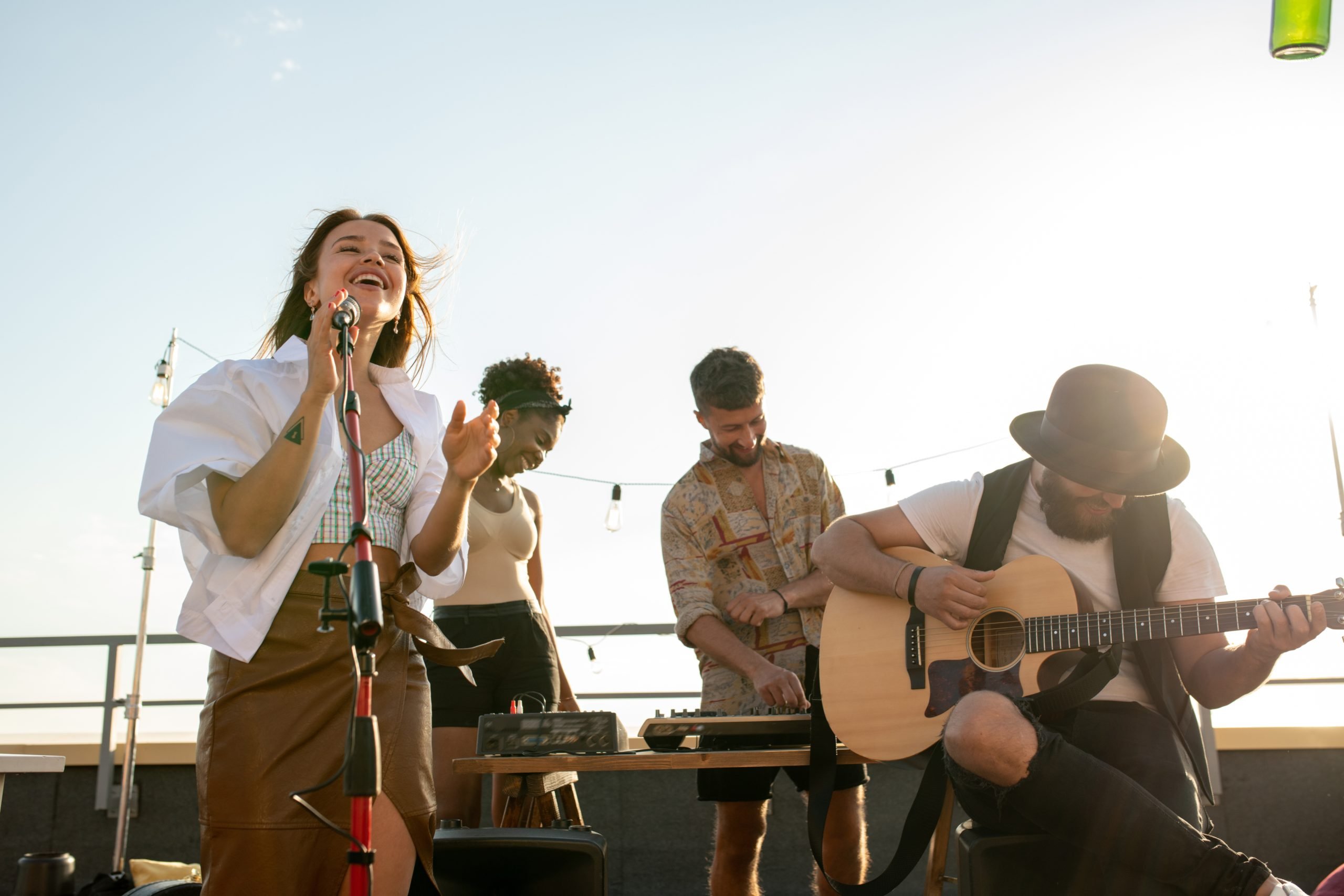 Outdoor live music performance with a female singer and guitarist in a relaxed setting.